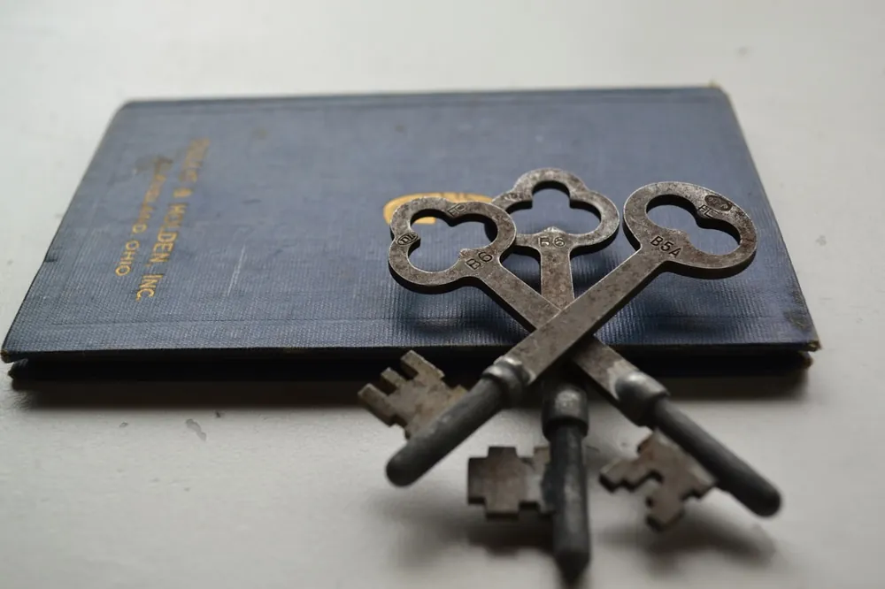 Illustrative still-life photograph of antique keys resting on a book, representing probate and family legacy matters.